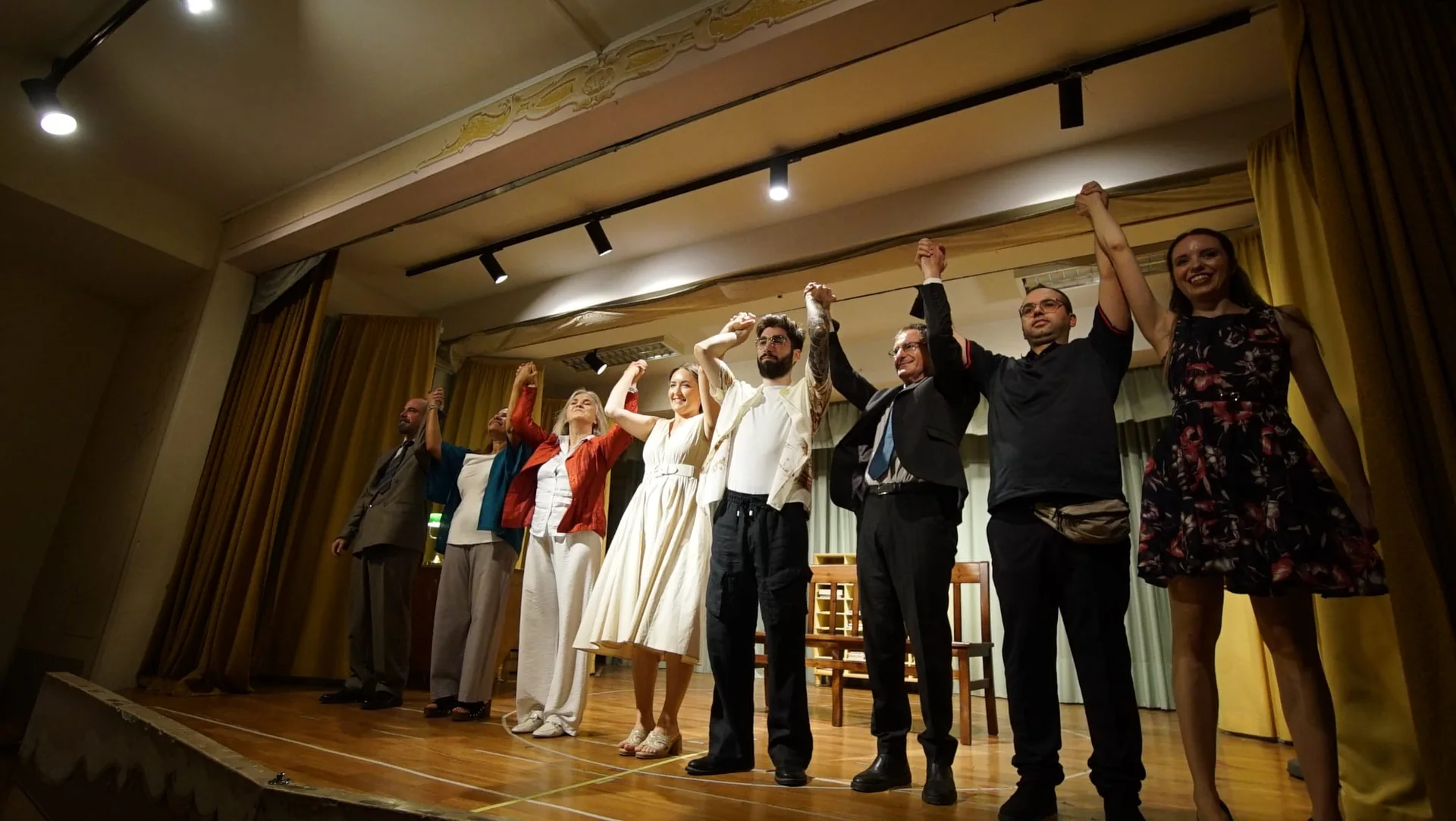 Il cast di Destino Libero saluta il pubblico sul palco al termine dello spettacolo
